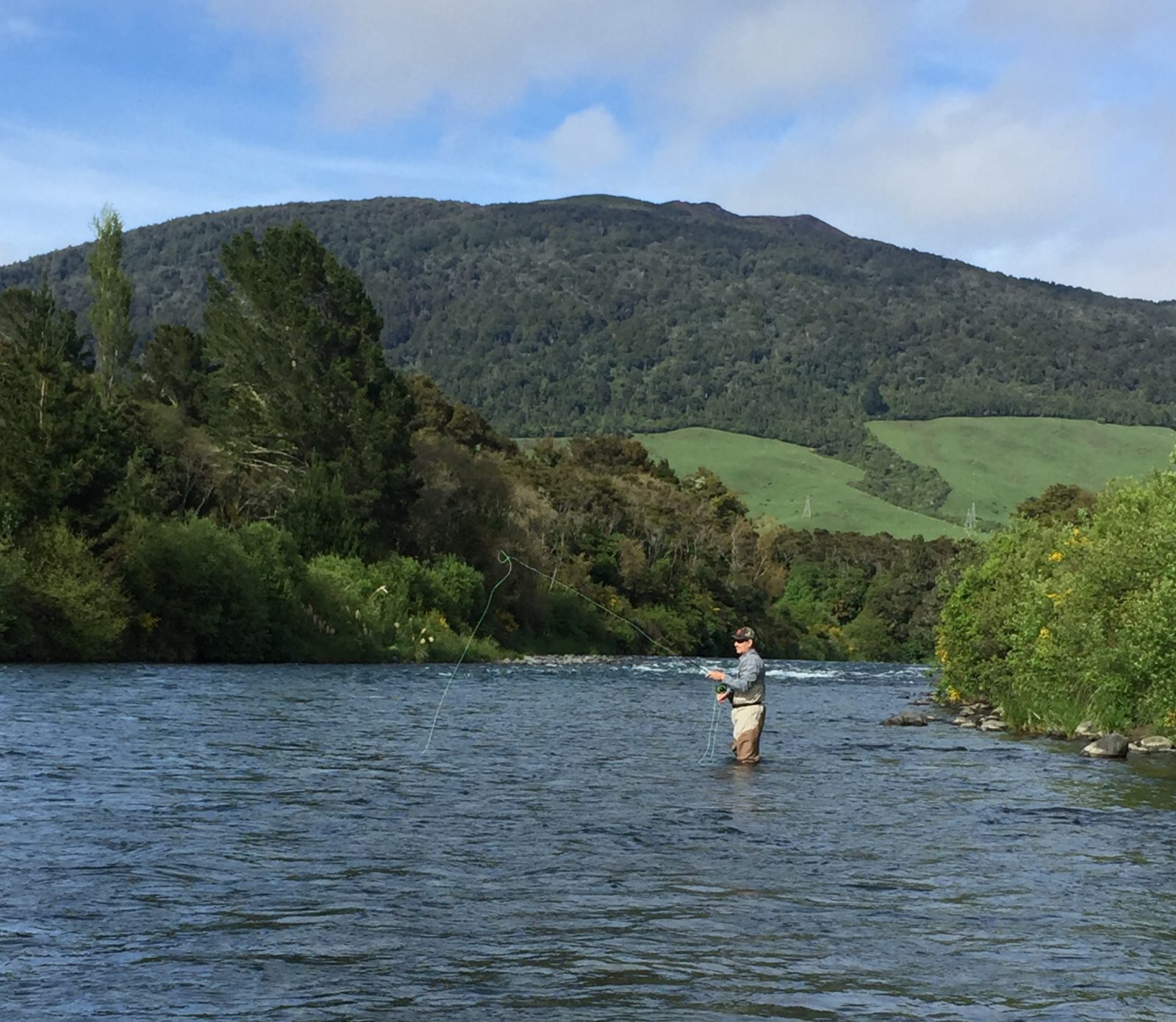 Fly fisherman standing in river NZ